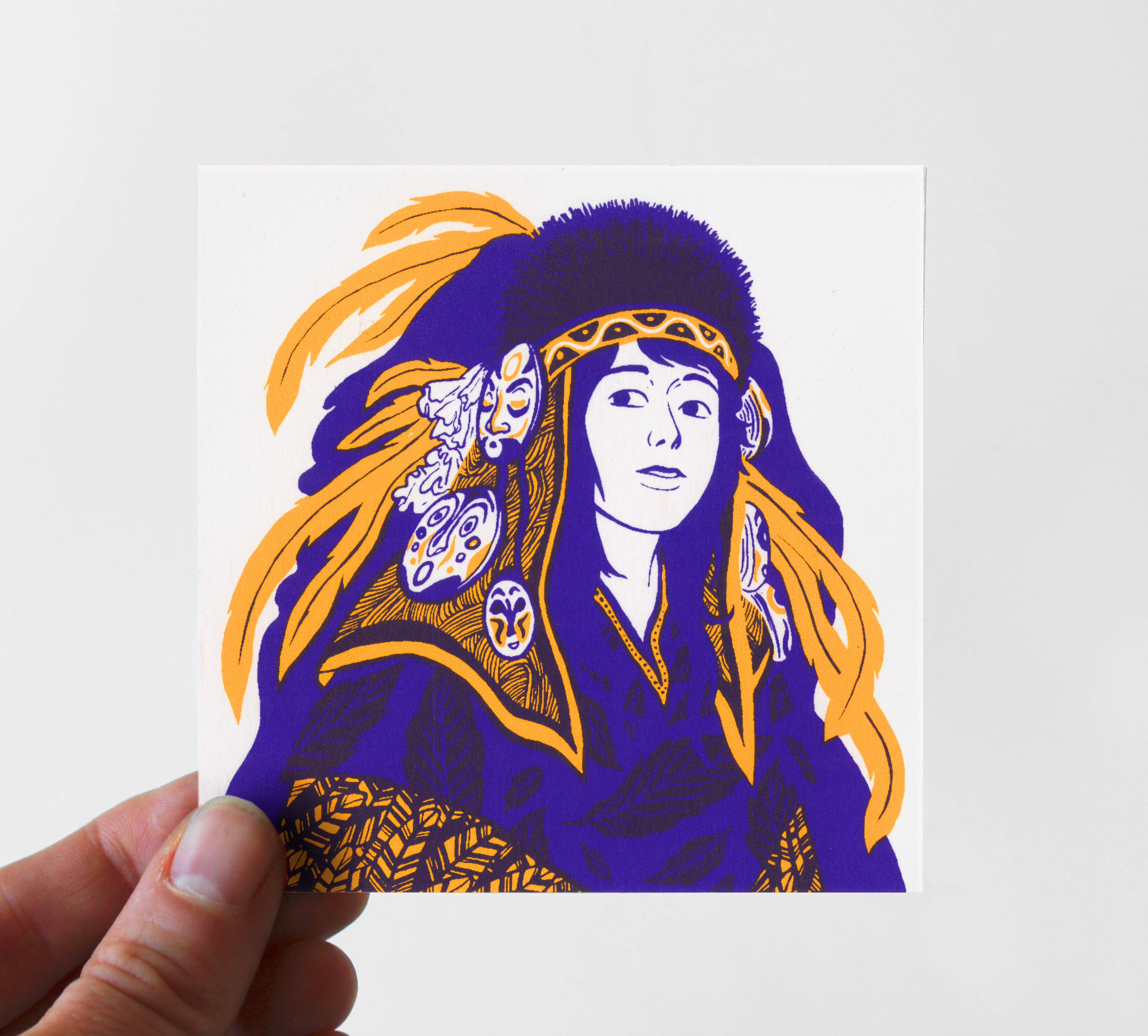 Photo d'une petite carte sérigraphié en deux couleurs, jaune et violet, représentant une femme avec une tenue traditionnelle imaginaire.