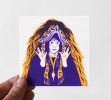Photo d'une petite carte sérigraphié en deux couleurs, jaune et violet, représentant une femme avec une tenue traditionnelle imaginaire, nous regardant.