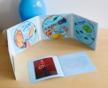 Photo of Jean René's 3-CD box set opened, showing the three illustrated CDs and the inner booklet on a wooden table.